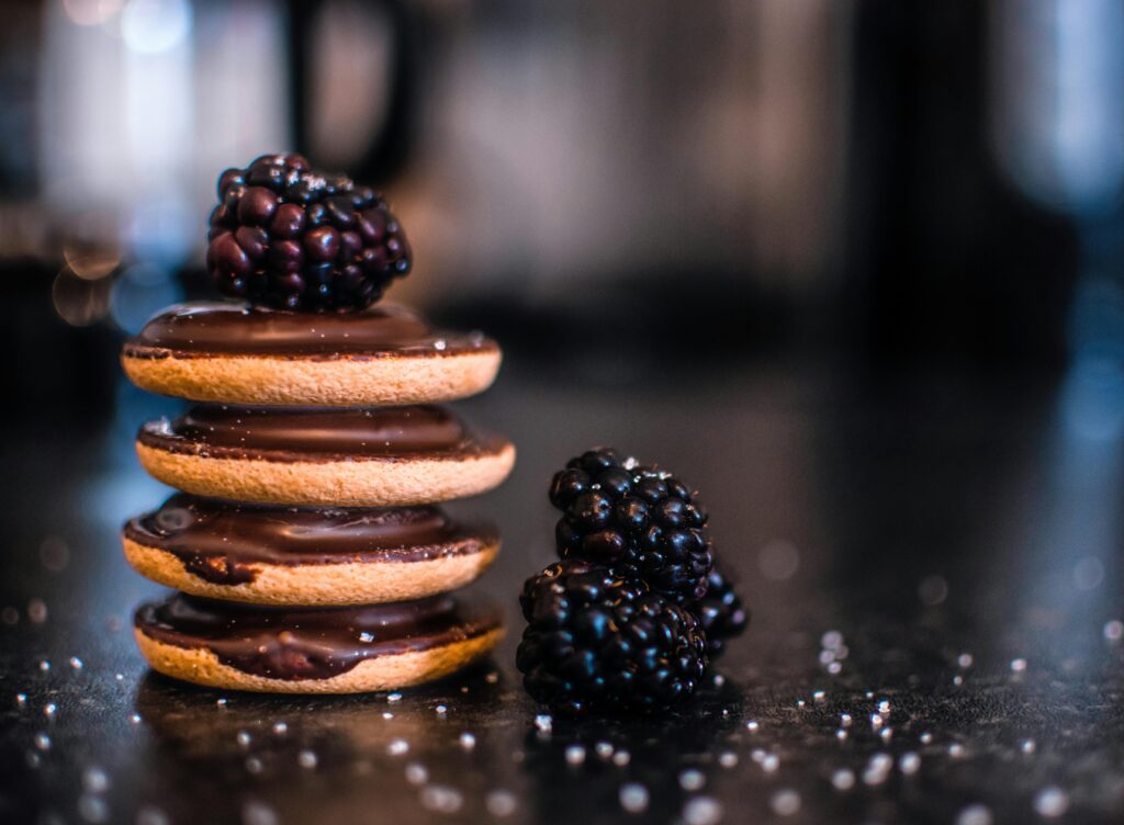 Delicious stack of chocolate-covered biscuits topped with fresh blackberries.